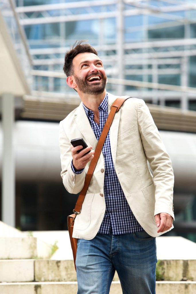 smiling-mature-man-outdoors-with-mobile-phone